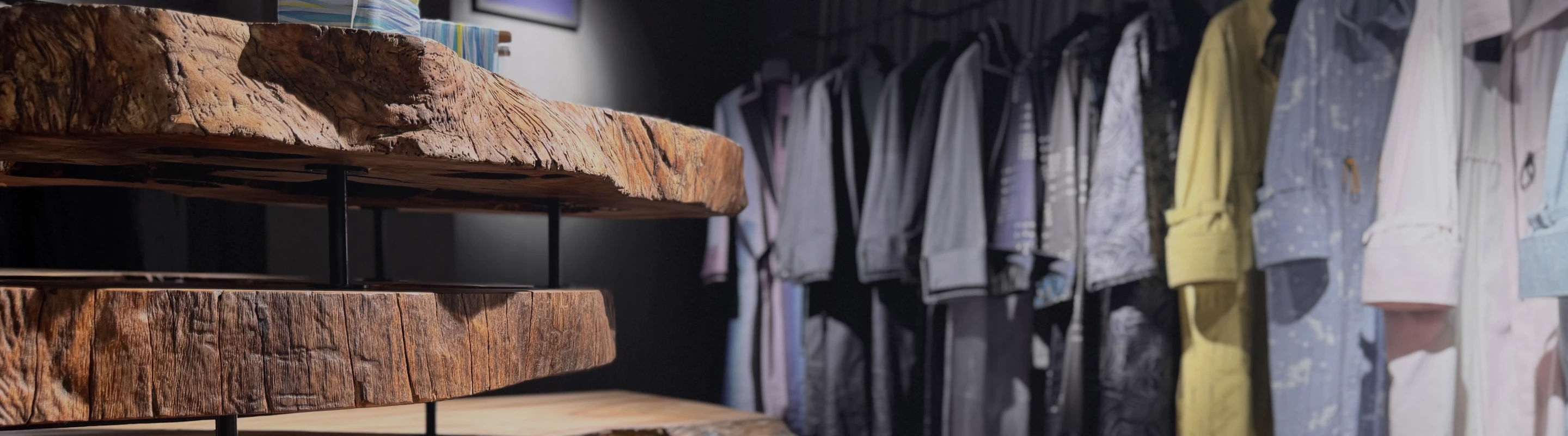 暗い照明の中で、深い紫と青のグラデーションが美しい米沢織のシャーリングコートの布が柔らかく波打っている様子。