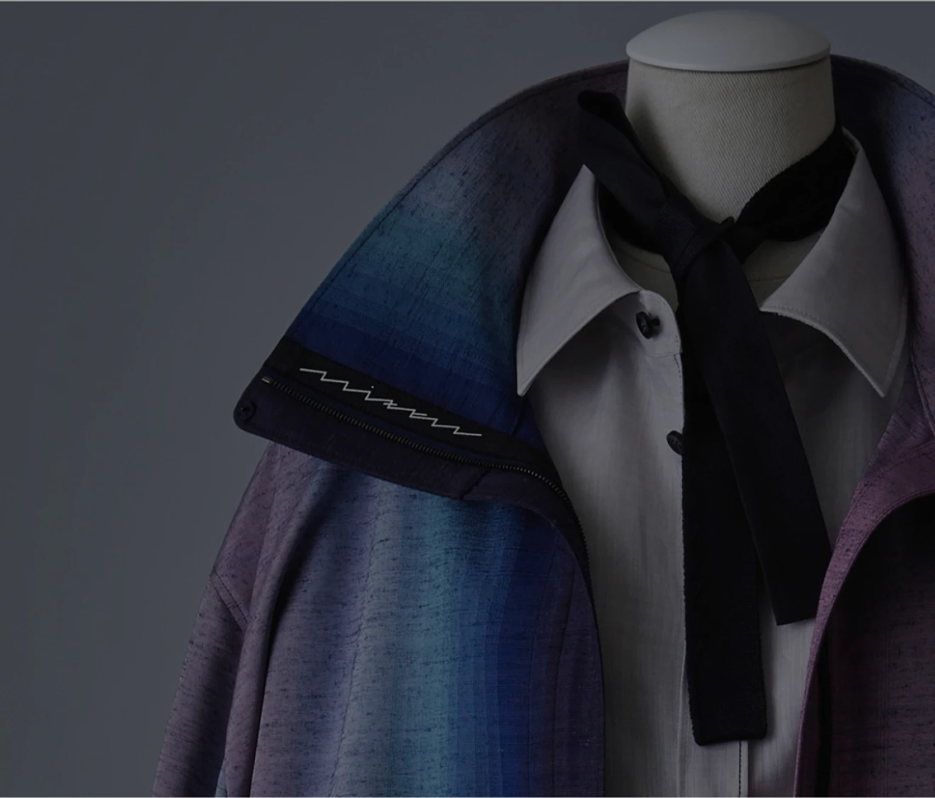 グラデーションのように紫から青へと色が移ろう羽織を着せたトルソーの上半身。白いシャツに黒いリボンタイを合わせ、上品で落ち着いた雰囲気の装いが強調されている。